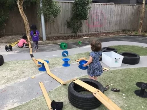 Children enjoying outdoor play with tyres, balance boards and loose parts at Moss Hall Playcentre